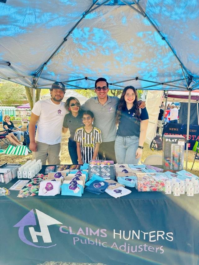 Equipo de Claims Hunters en una feria comunitaria al aire libre