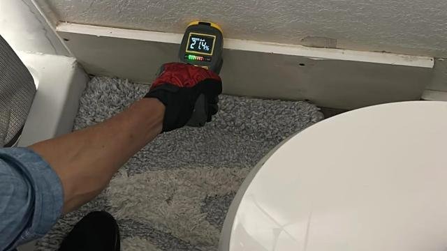Moisture meter reading taken at a baseboard